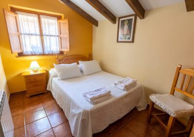Dormitorio cama matrimonio del apartamento 2, incluye ropa de cama y mantas. Apartamentos rurales Villa García. Turismo rural en Picos de Europa